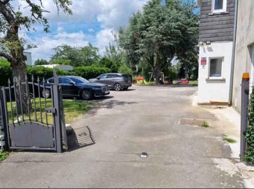 a parking lot with a gate and two cars parked at Bright and cozy room close to airport Grenier in Kampenhout