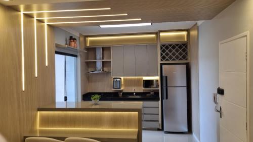 a kitchen with a refrigerator and a counter top at Luxo colado no Shopping in Franca