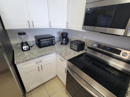 a kitchen with a stove and a microwave at Lakeview Condo Hotel near Disney in Orlando