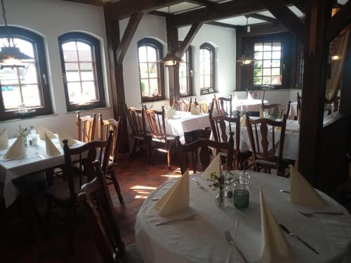 a dining room with white tables and chairs and windows at Fischstuebchen Neeberg in Krummin