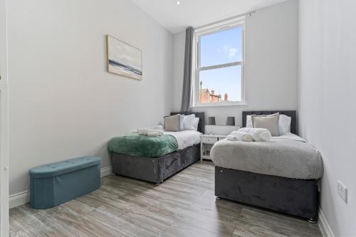 two beds in a room with a window at Harwich Luxury Suite in Harwich