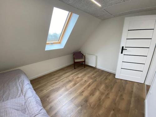 a bedroom with a bed and a window and a wooden floor at Sunny apartment in Åbybro