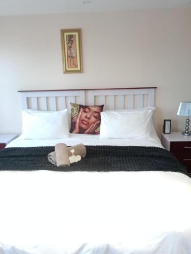 Bett mit einem Bild einer Frau auf dem Kissen in der Unterkunft Edladleni Guesthouse in East London