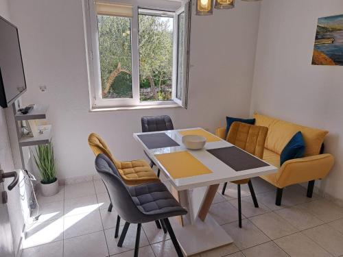 un soggiorno con tavolo da pranzo e sedie di La Petite Maison a Splitska