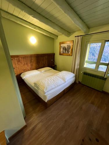 a bedroom with a bed in a room with a window at Hotel Riva Sport & Wellness in Vione