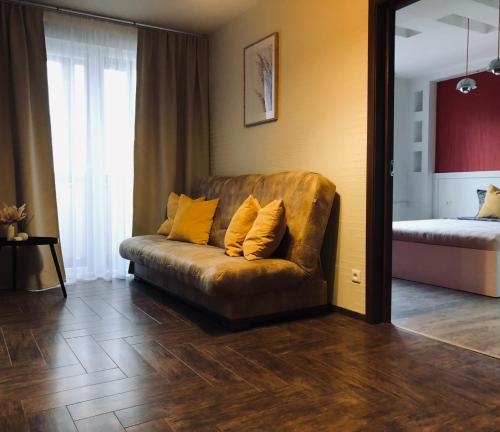 a couch with two pillows on it in a living room at Apartamentai Kęstučio g. Šilutėje in Šilutė