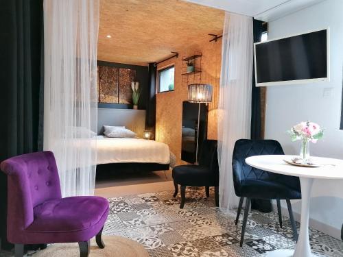 une chambre d'hôtel avec un lit, une table et des chaises dans l'établissement le Ti'Cocoon, à Langueux