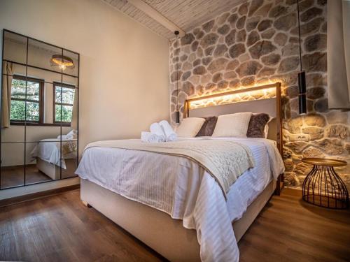 a bedroom with a large bed and a stone wall at Αρχοντικό Πορταριάς in Portariá