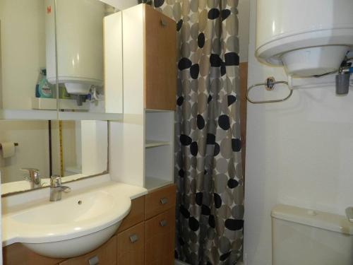 une salle de bain avec un lavabo et un rideau de douche dans l'établissement Studio au cœur de la Favière, proche plage et commerces, avec parking privatif et ménage inclus - FR-1-251-814, à Bormes-les-Mimosas