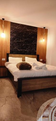 a bedroom with a large bed with a brown pillow on it at Villa Saar in Mas'ade