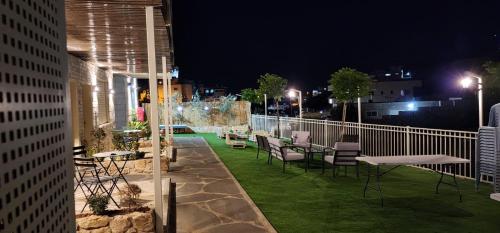 a rooftop patio with tables and chairs at night at Villa Saar in Mas'ade