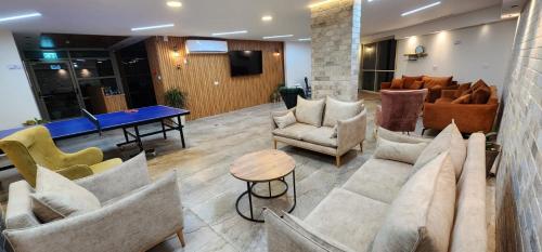 a lobby with couches and a table and chairs at Villa Saar in Mas'ade