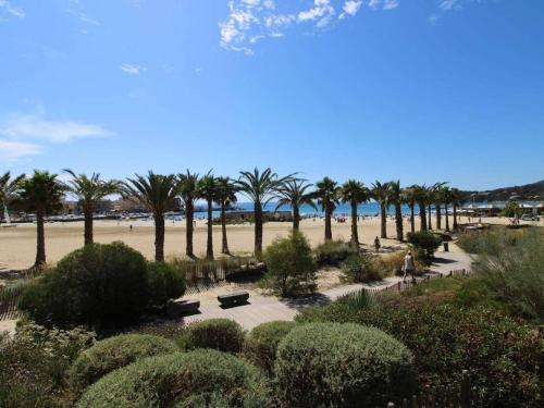un parc avec des palmiers et une plage de sable dans l'établissement Studio au cœur de la Favière, proche plage et commerces, avec parking privatif et ménage inclus - FR-1-251-814, à Bormes-les-Mimosas