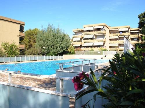 - une piscine en face d'un immeuble dans l'établissement Appartement familial avec piscine et tennis, proche plage - 6 couchages, Bormes-les-Mimosas - FR-1-251-817, à Bormes-les-Mimosas