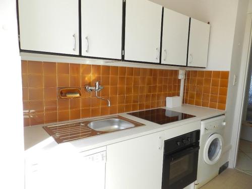 une cuisine avec un évier et une machine à laver dans l'établissement Appartement T2, 4 couchages, parking, bord de mer - FR-1-251-820, au Lavandou
