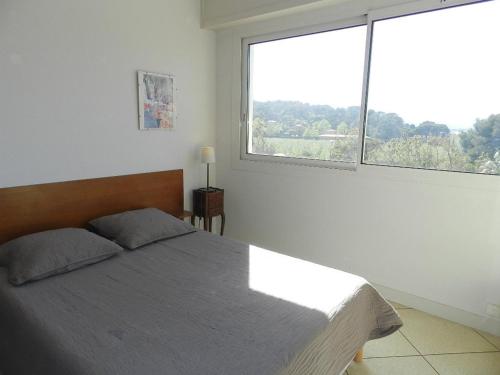 une chambre avec un lit et une grande fenêtre dans l'établissement Appartement T2, 4 couchages, parking, bord de mer - FR-1-251-820, au Lavandou