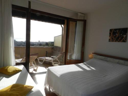 um quarto com uma cama e vista para uma varanda em Appartement Bormes-les-Mimosas, 2 pièces, 4 personnes - FR-1-251-807 em Bormes-les-Mimosas