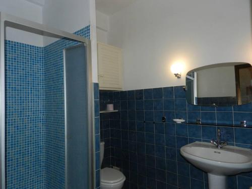 uma casa de banho em azulejos azuis com um lavatório e um espelho em Appartement Bormes-les-Mimosas, 2 pièces, 4 personnes - FR-1-251-807 em Bormes-les-Mimosas