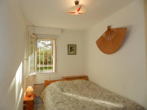 een slaapkamer met een bed en een raam bij Appartement Bormes-les-Mimosas, 2 pièces, 4 personnes - FR-1-251-810 in Bormes-les-Mimosas