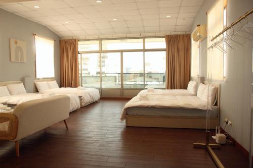 a bedroom with two beds and a large window at 聖水洞民宿성수동 in Tainan