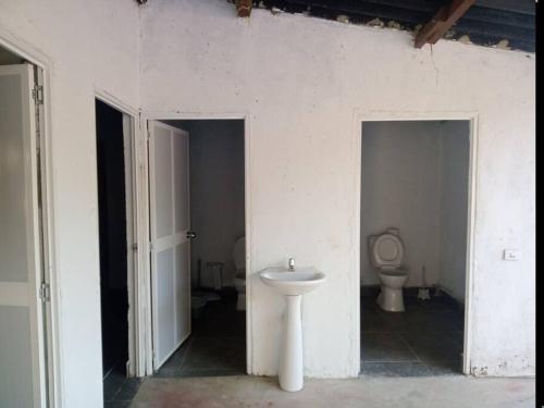 Oso Hostel Cabaña Santa Marta في سانتا مارتا: حمام أبيض مع حوض ومرحاض