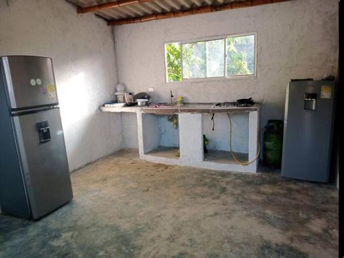 Oso Hostel Cabaña Santa Marta في سانتا مارتا: مطبخ مع كونتر وثلاجة في الغرفة