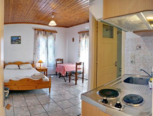 ein Schlafzimmer mit einem Bett und eine Küche mit einem Waschbecken in der Unterkunft Angelos Rooms in Mytilini
