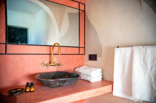 a bathroom with a stone sink and a mirror at Kasbah Zitoune in Ouarzazate