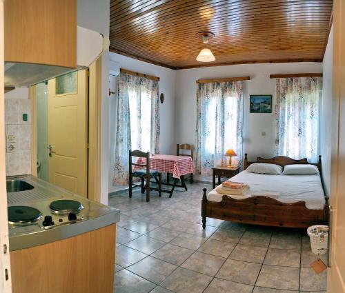 eine Küche und ein Schlafzimmer mit einem Bett in einem Zimmer in der Unterkunft Angelos Rooms in Mytilini