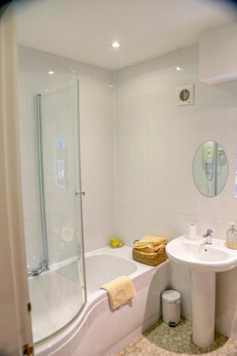 a white bathroom with a shower and a sink at Harbour Cottage, Conwy in Conwy