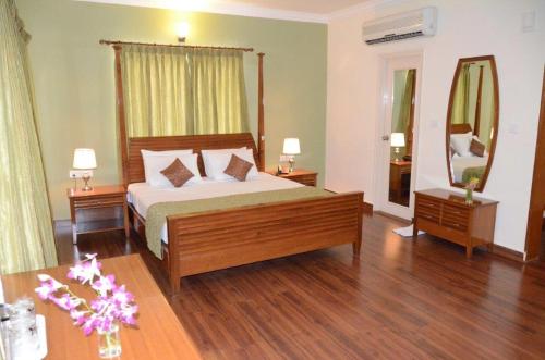 a bedroom with a bed and two tables and a mirror at Trinity Suites in Bangalore