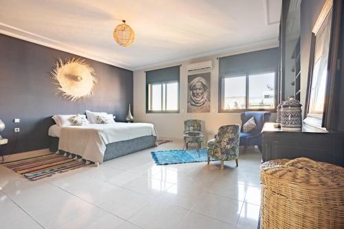 Un dormitorio con una cama y algunas sillas. en Penthouse avec Jacuzzi privé à Marrakech, en Marrakech