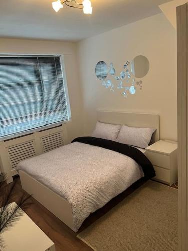 a bedroom with a bed and a window at Flat in White city - Westfield in London