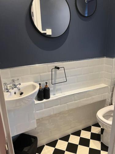 een badkamer met een wastafel, een toilet en een spiegel bij Flat in White city - Westfield in Londen