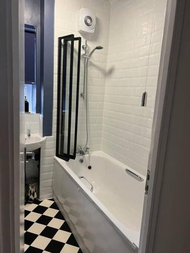 a white bathroom with a tub and a sink at Flat in White city - Westfield in London