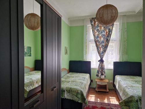 una camera con due letti e una finestra di Етаж от къща с двор a Burgas
