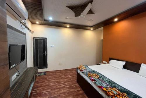 バラナシにあるHotel Varanasi Paradise - Best Seller - Parking facilitiesのベッドルーム(ベッド1台、薄型テレビ付)