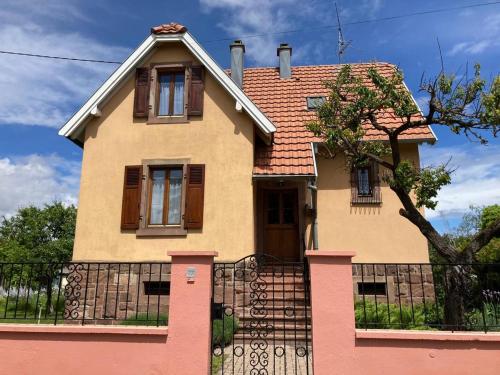 La Maison de Vacances de Colmar et son jardin في كولمار: منزل امامه سياج