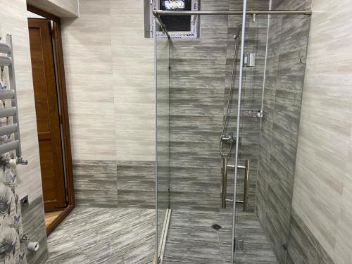 a shower with a glass door in a bathroom at Viva Hotel Gabala with Sauna, Pool, Waterfall and Fireplace in Gabala