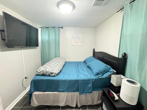 Dormitorio pequeño con cama y TV en Executive Apartment at Uplands en Baltimore