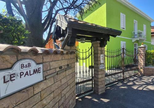 a sign on a brick fence in front of a house at B&B Le Palme in Appiano Gentile