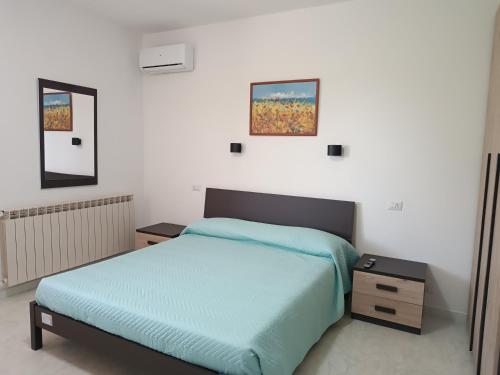 a bedroom with a bed and two night stands at Spiaggia LazzarettoHouse in Alghero
