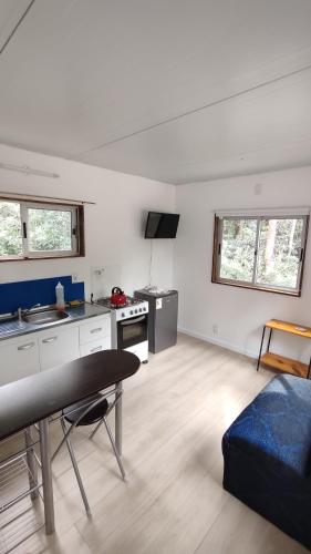 a kitchen and living room with a table and a couch at Tiny house, casa de playa océan park in Ocean Park