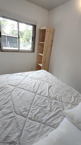 a large white bed in a room with a window at Tiny house, casa de playa océan park in Ocean Park