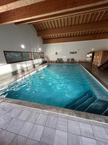 une grande piscine intérieure d'eau bleue dans l'établissement Studio Orelle 3 Vallées - Spa & Piscine - Apt 006, à Orelle