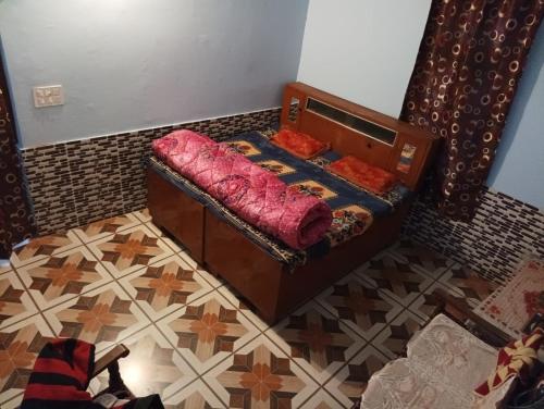 a small bed in a room with a tiled floor at Badal Home Stay @ Jawalaji in Kangra