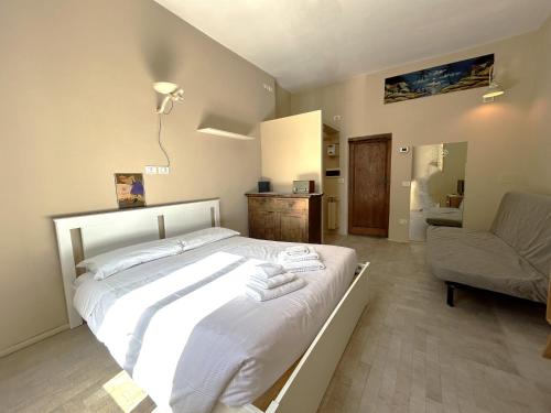sypialnia z białym łóżkiem i krzesłem w obiekcie Appartamento Firenze Mayer we Florencji