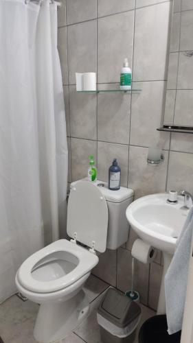 La salle de bains est pourvue de toilettes blanches et d'un lavabo. dans l'établissement Alquiler Temporario Río Grande, à Río Grande