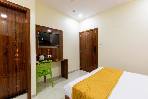 um quarto com uma cama, uma secretária e uma televisão em Hotel New Imperial em Mumbai