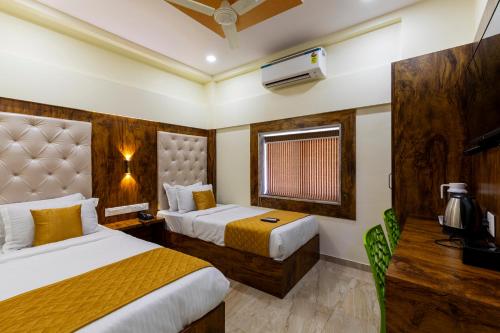 ムンバイにあるHotel New Imperialのベッド2台とテレビが備わるホテルルームです。